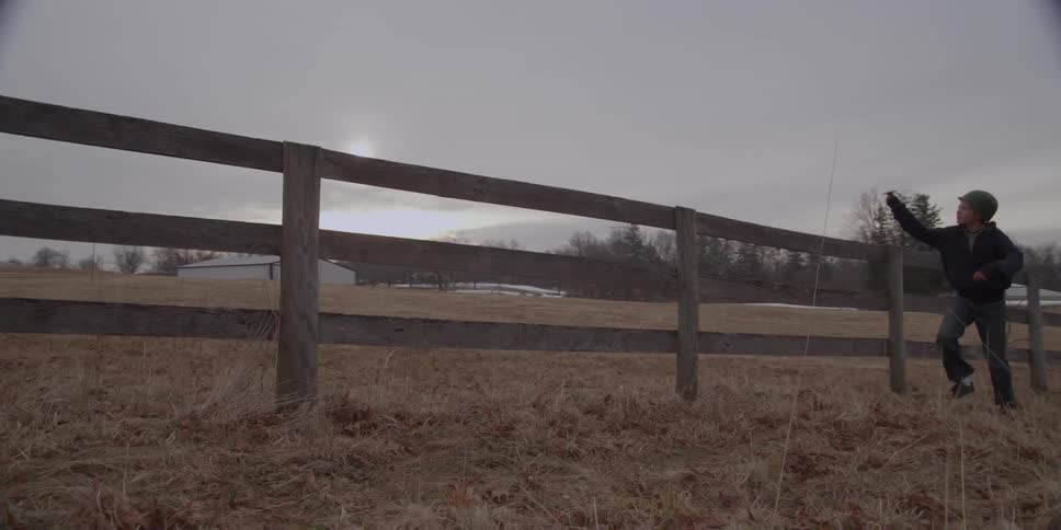 A child running past a wooden fence