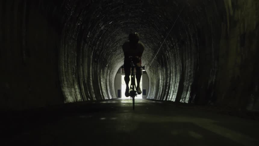 A bicyclist rides through a tunnel