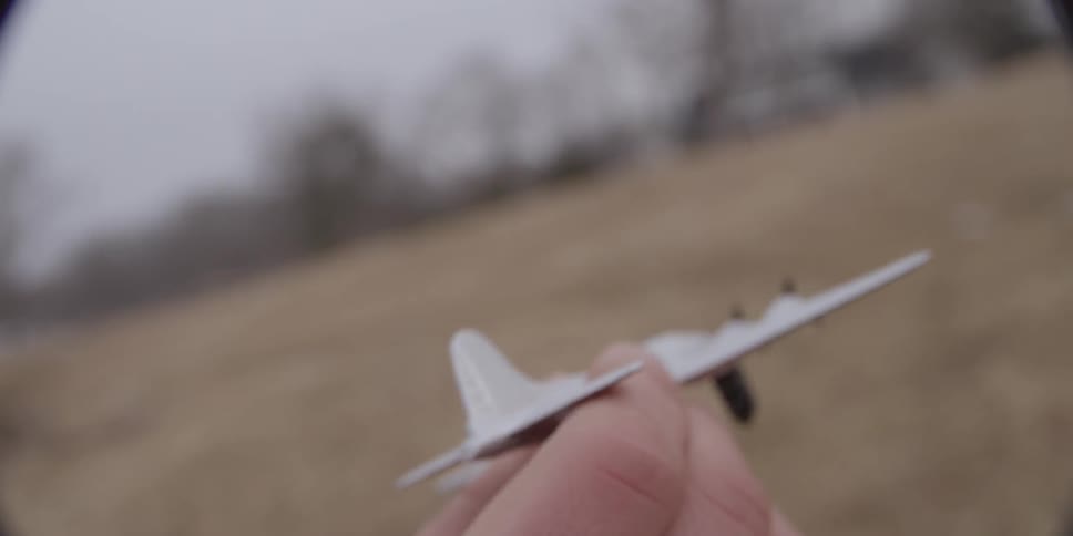 Boy flies a toy airplane through the air