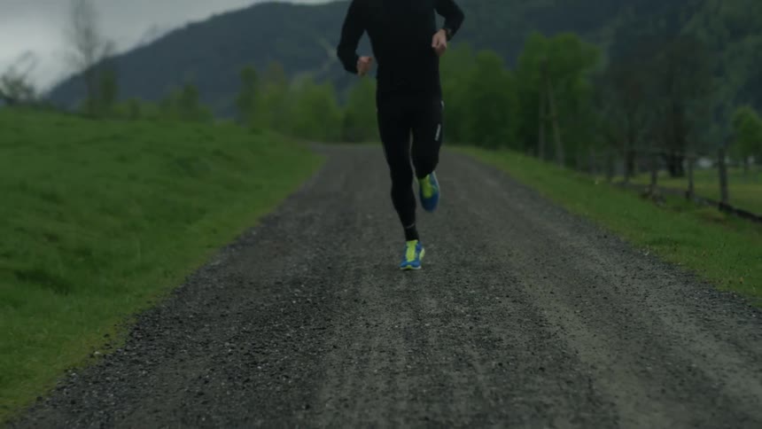 Person runs on a stone path in the country on a cloudy day