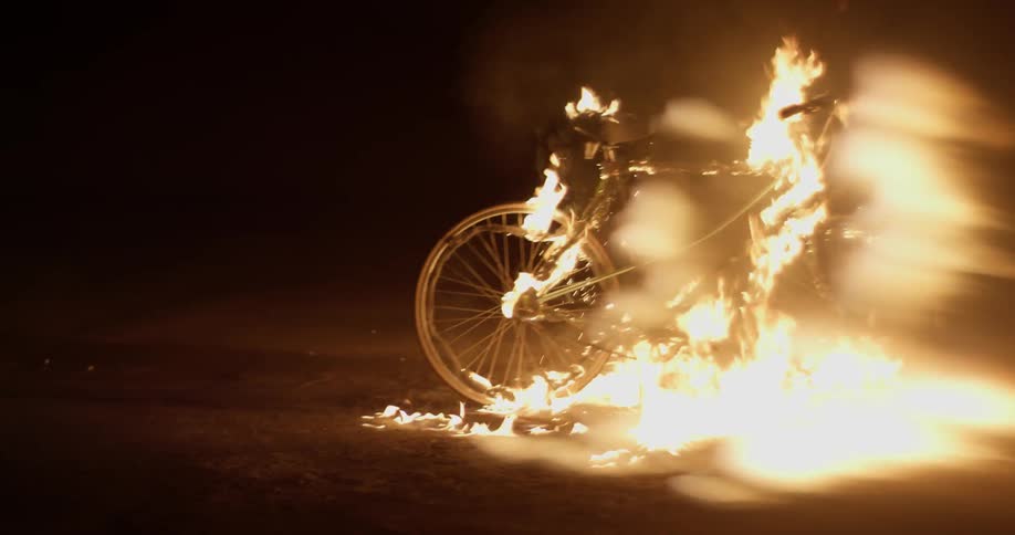 A bicycle is on fire at night
