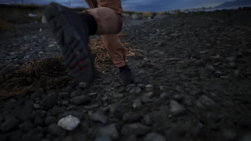 Person jumps and runs over rocky terrain