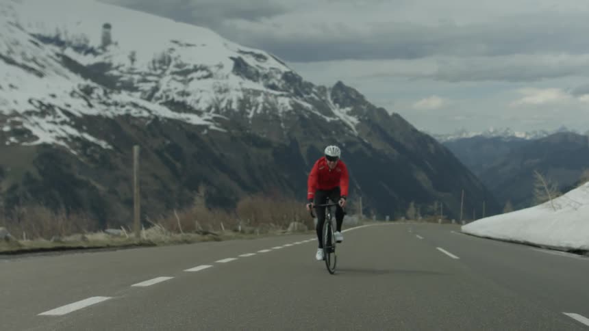 Man pedals bike in the middle of a country road