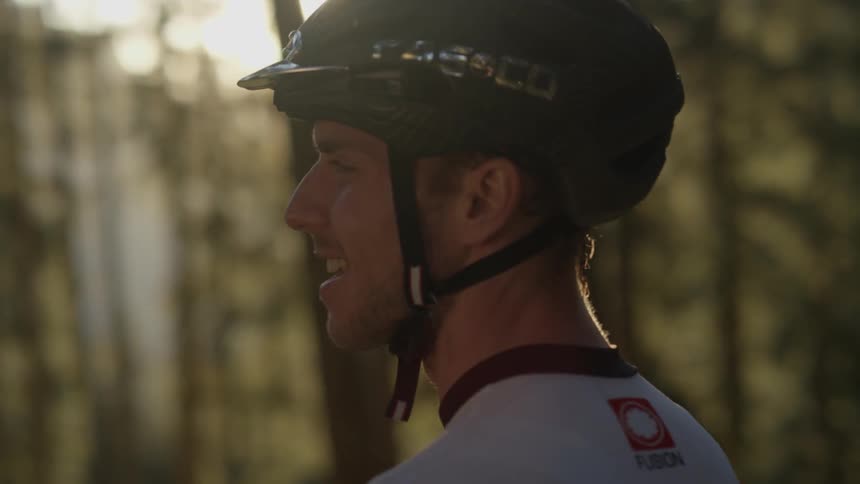 A bicyclist is stopped in a forest