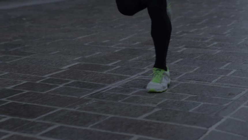 A jogger runs on a brick sidewalk