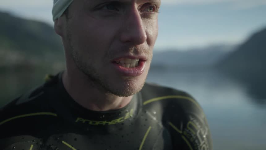 A man's teeth chatter while swimming in a lake