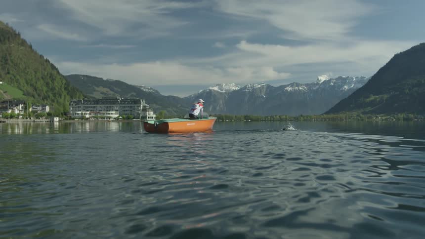 A person is fishing off a small boat on the lake