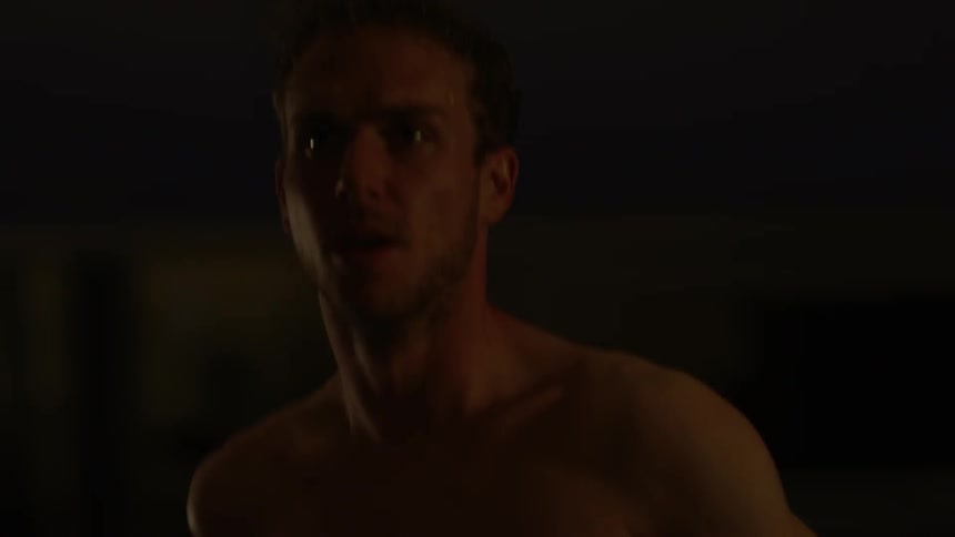 A shirtless man jogs in the dark