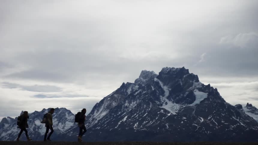 A group of friends who are hiking in a natural landscape are jumping and posing