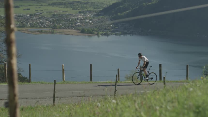 A bicyclist rides on a mountain road