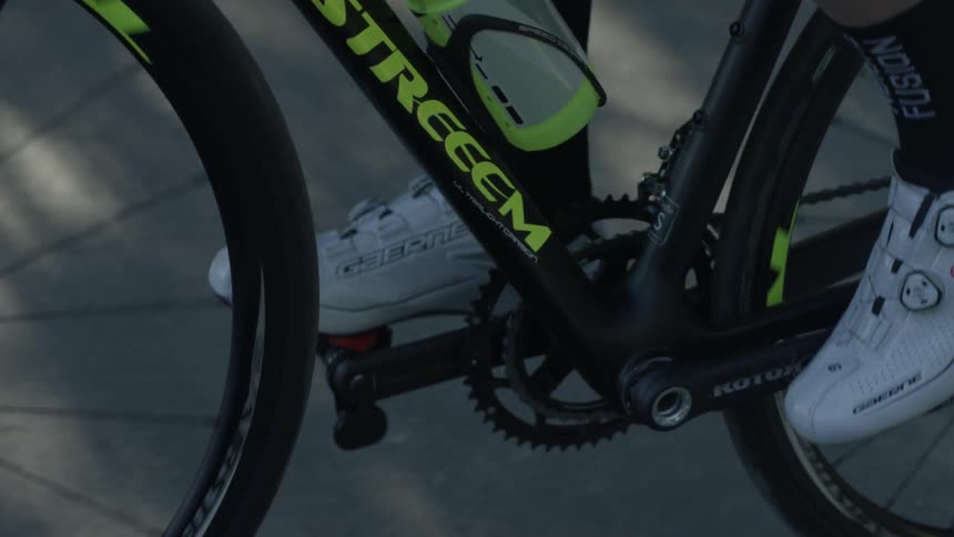 Person pedals a black bike on pavement