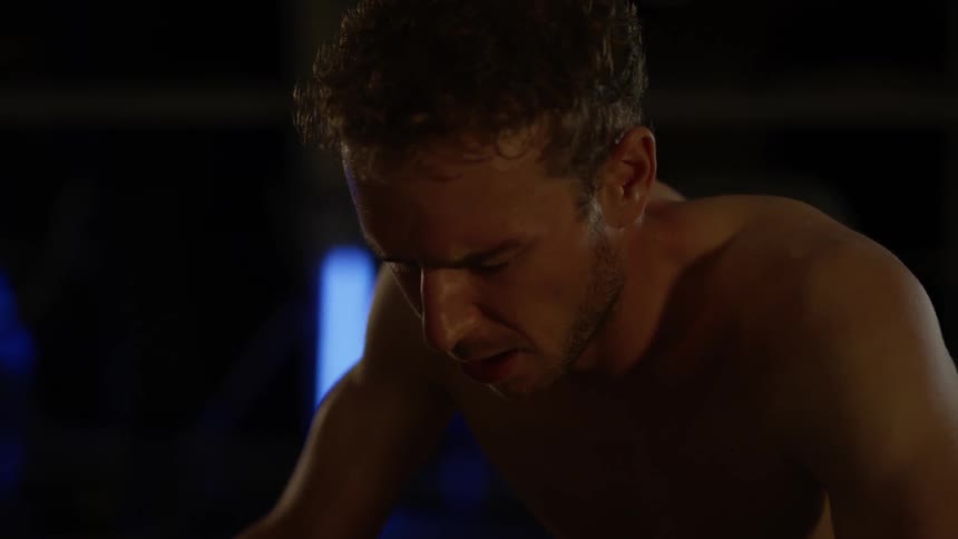 A man is leaning forward breathing heavy