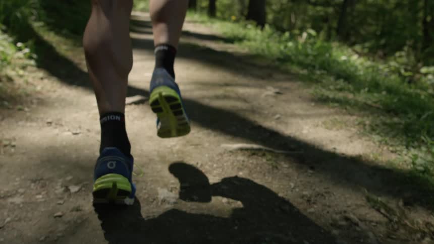 A jogger runs on a forest trail