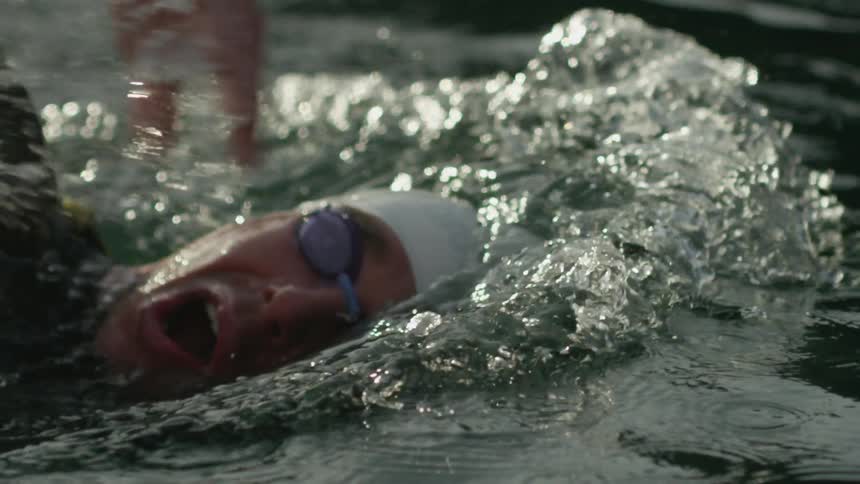 A swimmer splashes the water as he travels