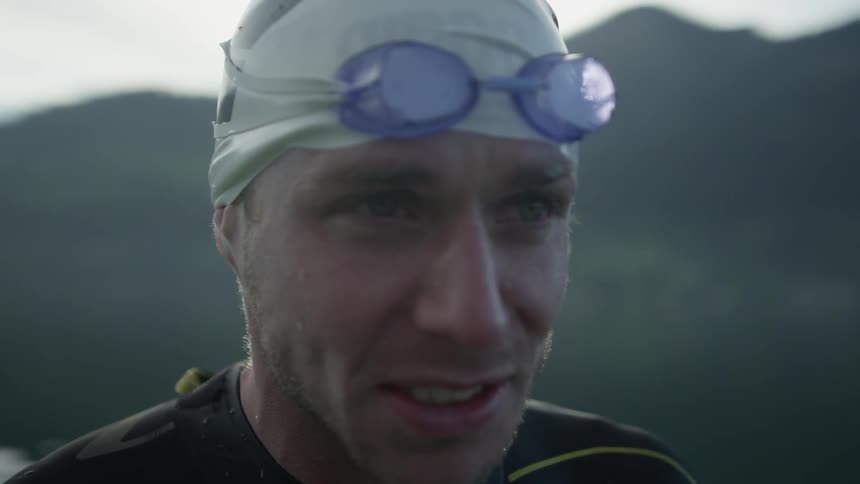 A wet swimmer stands outside