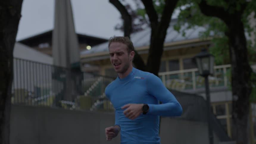 A man jogs on a city sidewalk