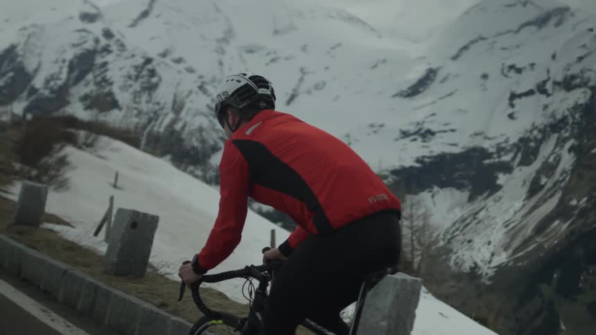 Man rides his bike through the snowy mountains