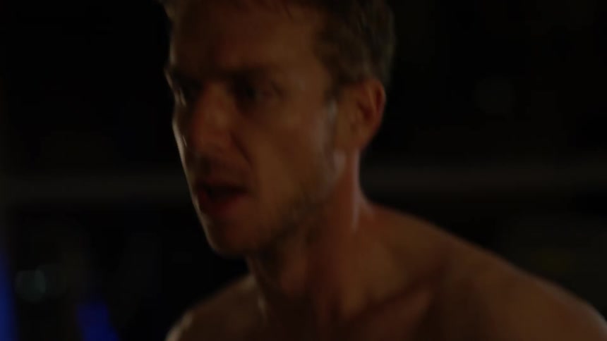 A shirtless man jogs in the dark