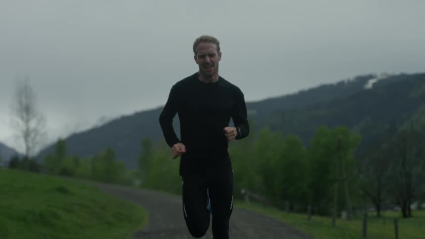 A man jogs outside down a trail