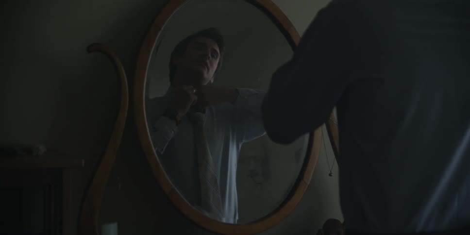 Man fixing his clothes in a mirror