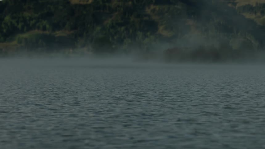 Lake waters flow next to a mountain