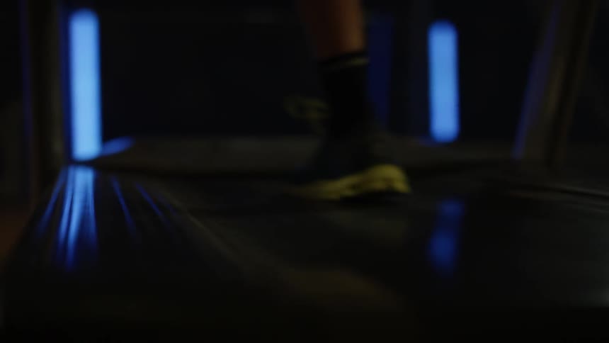 A man is jogging on a treadmill inside in daylight