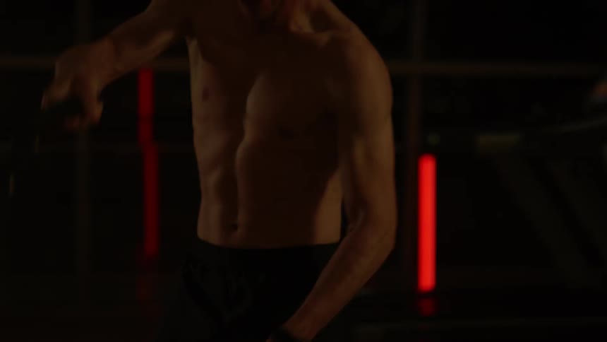 A man exercises with chains in a gym