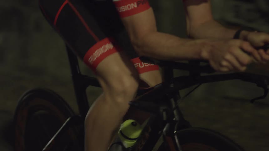 A man is leaning forward riding his bicycle