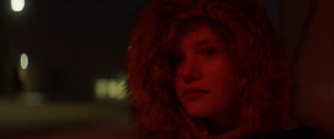 A girl is walking outside at night time
