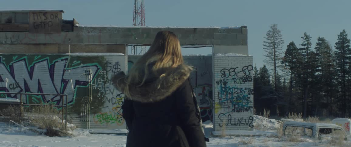 A woman looks at graffiti on a building