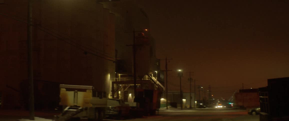 There is a bright light at the top of the building ahead