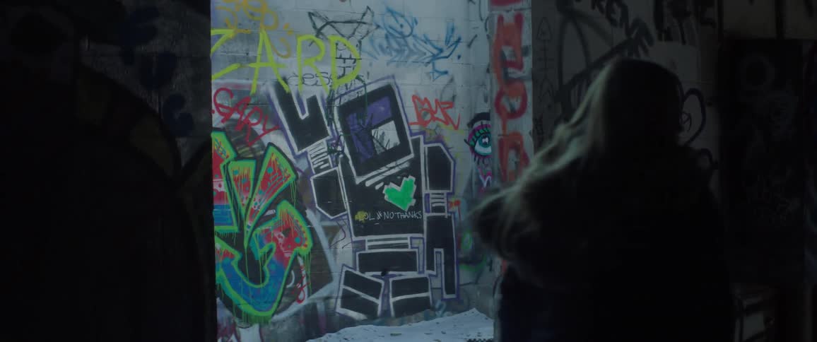 A woman walks by graffiti