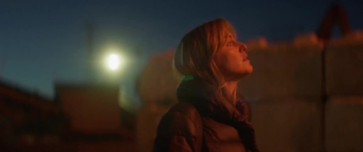 A woman walks outside at night