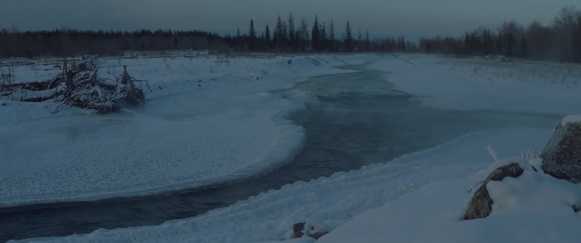 The stream is surrounded by ice in the wilderness