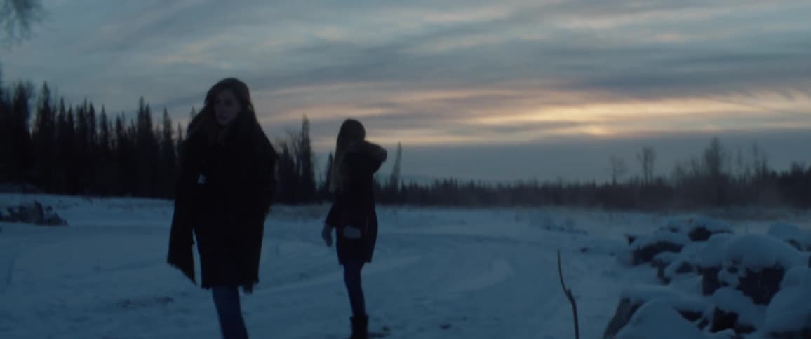 Two young women walk outside in the snow
