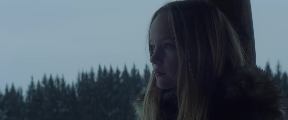 A teenage girl is standing in thought outside in winter
