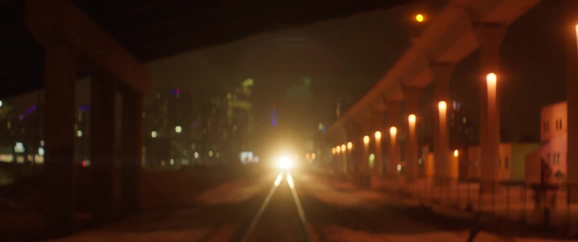 A train travels down the tracks at night