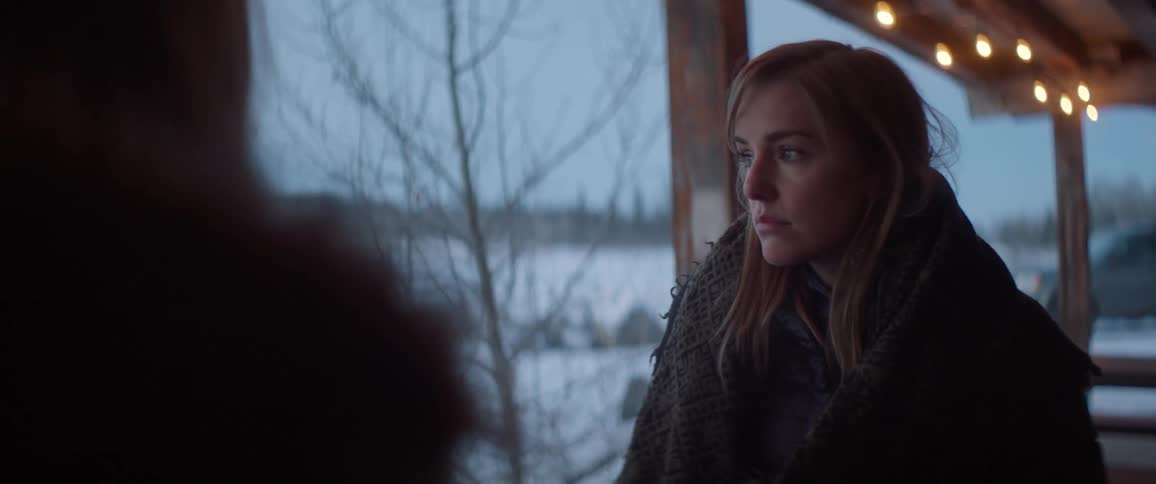 Two women are standing on the porch together