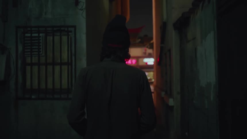 A man walks in a dark alley