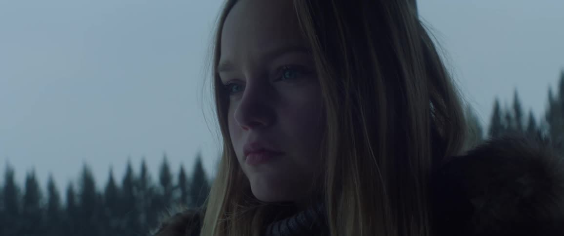 A girl stands outside and stares on a winter day