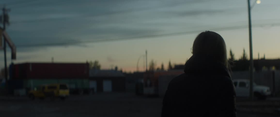 A woman looks back then walks forward at sunset