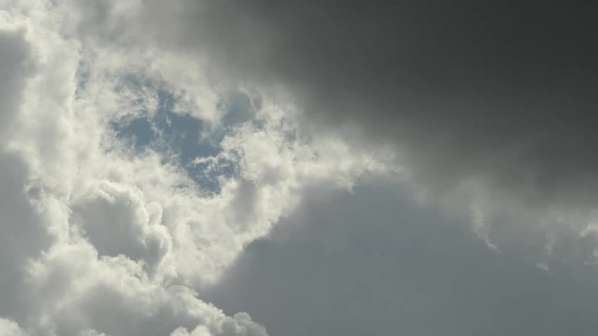 The sun is peeking into the thick clouds in the sky