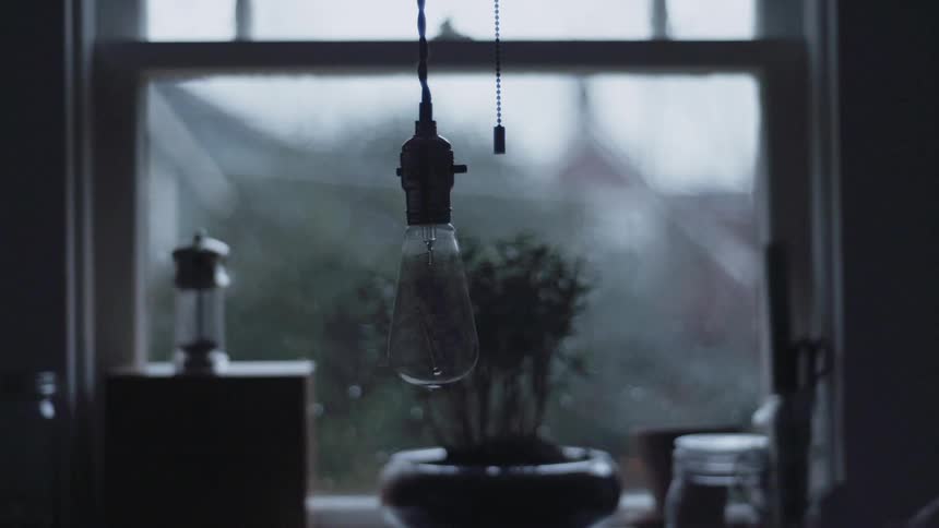A light bulb is hanging in the dark room