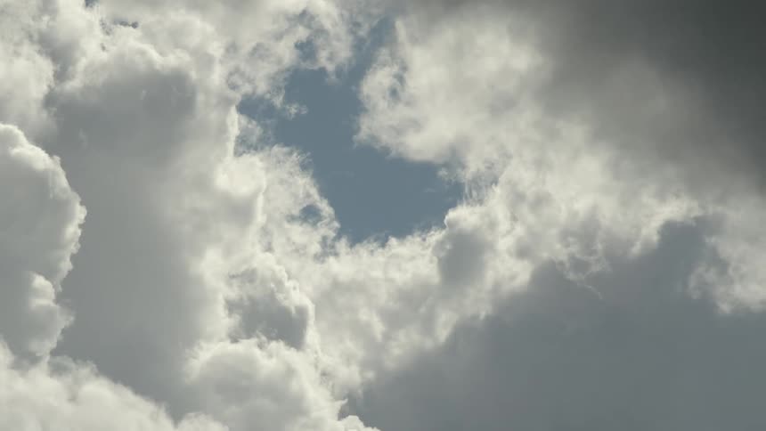Clouds are billowing and drifting in the sky in daylight
