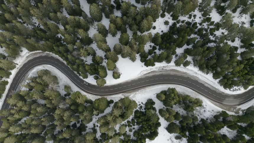 A vehicle is traveling around the winding road below