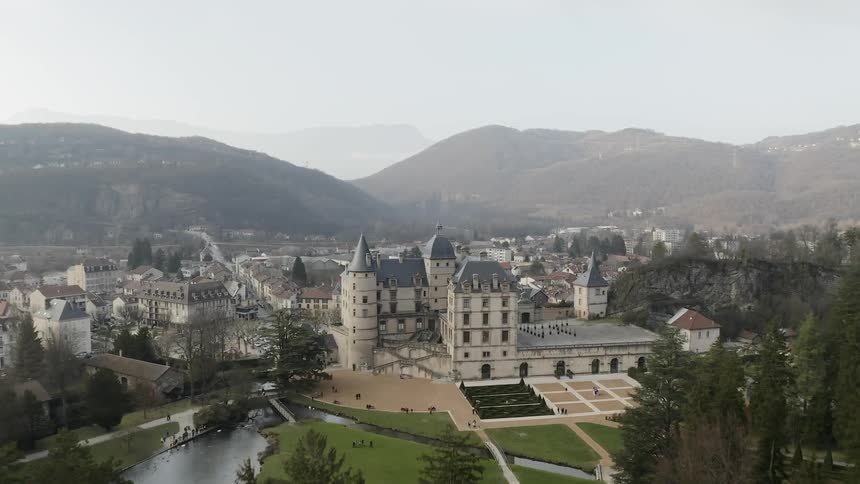 People walk around the grounds and courtyard of a palace
