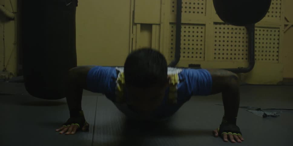 Person does pushups in a dim room