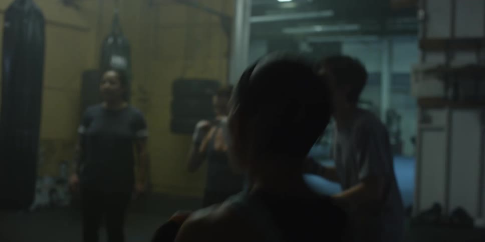 A group of people do lunges in a gym