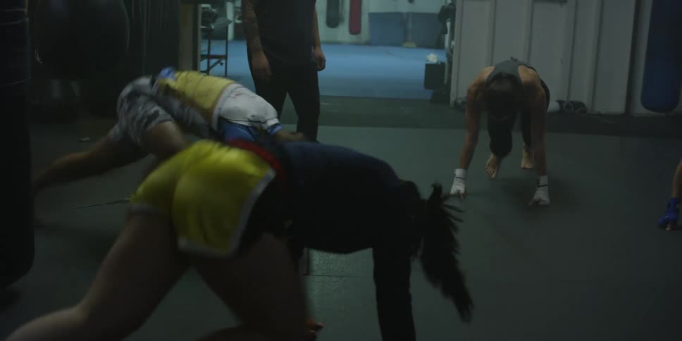 Several people exercise in a dimly lit gym