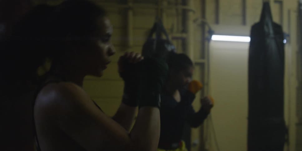 Men and women shadow box and train in a gym